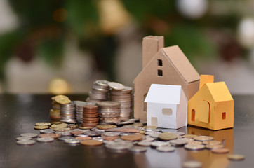 Paper house and stacks of coins standing