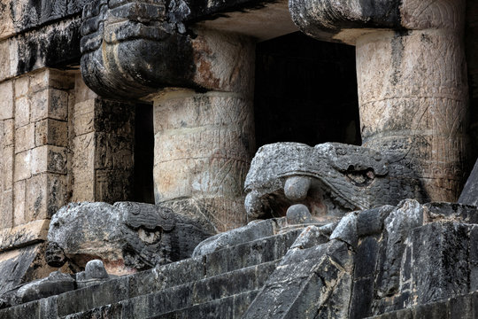 The upper level of the Temple of the Jaguars with the carved heads of Kukulcan, facing the great Ball Court in Chichen Itza, Yucatan, Mexico.