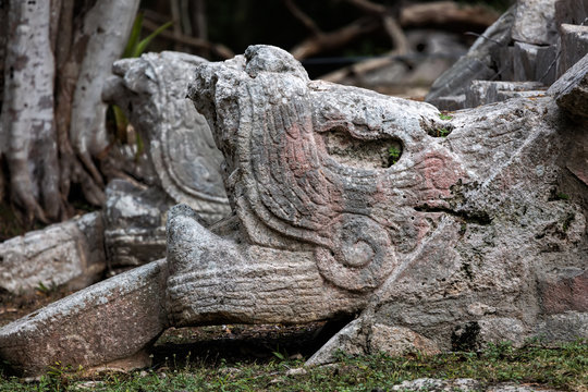 Head of a serpent with its tongue out at the base of the staircase of the Ossuary pyramid at the Chichen Itza archaeological site in Yucatan, Mexico.