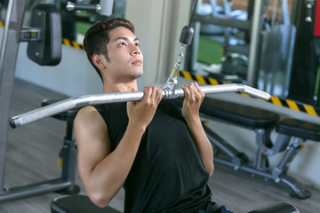 Fototapeta na wymiar Asian sport man making elevations. Bodybuilder training in gym