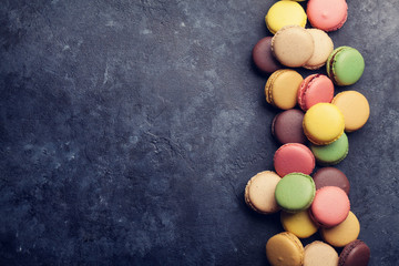 Colorful macaroons on stone table. Sweet macarons