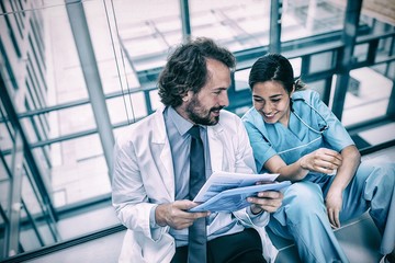 Happy doctor discussing with nurse over report
