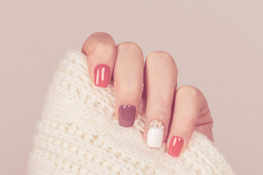 Beautiful colored pastel colors nail polish on hand, closeup. Nail art manicure concept