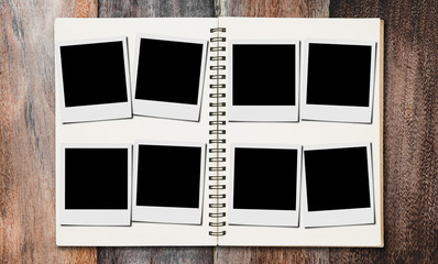 Blank photo frames in photos album, on wooden desk backgrounds