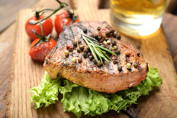 Grilled beef steak with rosemary, salt and pepper on cutting board