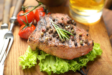 Grilled beef steak with rosemary, salt and pepper on cutting board