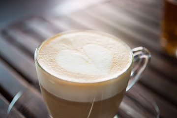 Close up of cappuccino cup with heart shaped milk pattern at caf