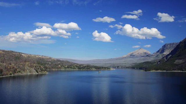Time Lapse of Clouds & Waves on Clear Blue Lake, Surrounded by Mountains - Tracking shot