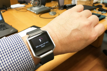 Perspective view of person reading watch with heart steps tracke