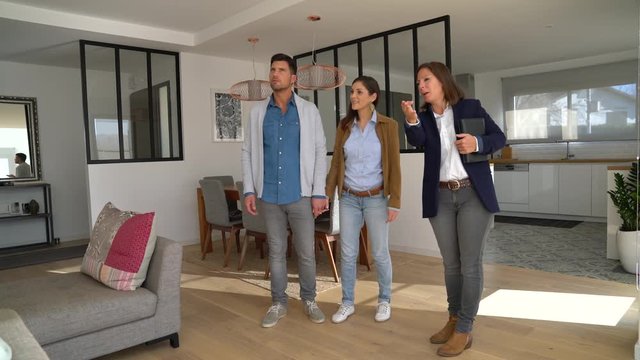 Couple with real-estate agent visiting house for sale