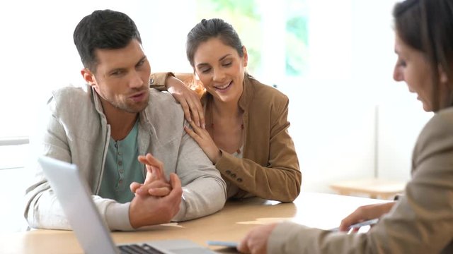 Couple meeting financial adviser for contract signature