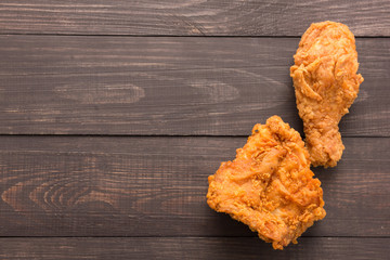 Fried chicken drumstick and chicken breast on the wooden backgro