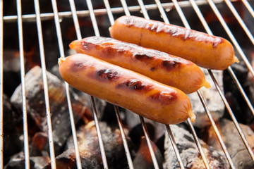 BBQ sausage on a flaming BBQ grill
