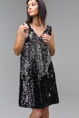 Girl in black dress with sequins looking away