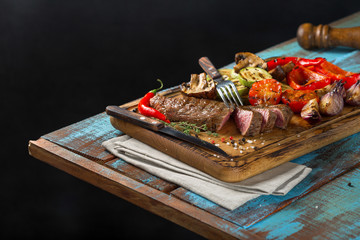 Sliced steak grill with grilled vegetables on the wooden table
