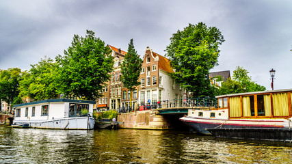 Fototapeta na wymiar Historic houses dating back to the Middle Ages along the canals seen from a boat in canals of Amsterdam