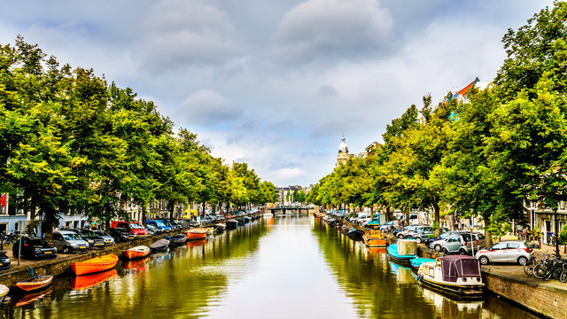 Boats moored along the tree lined canals of Amsterdam