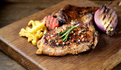 Grilled beef steak with rosemary, salt and pepper on cutting board