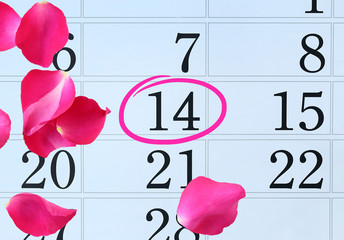 Calendar page with pink petals rose and pink circle mark on February 14 of Saint Valentines day.