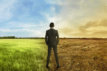 Asian businessman standing between different climate