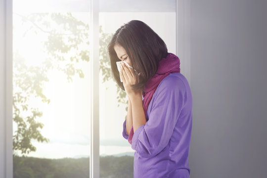 Sick Asian Woman Holding A Tissue In Her Nose