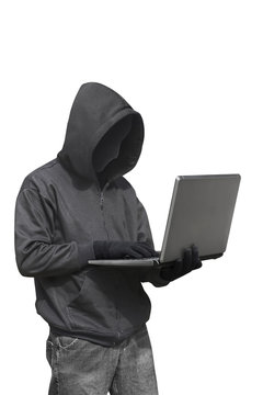 Hacker with anonymous mask with laptop while standing