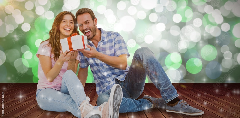 Poster Composite image of happy young couple holding gift