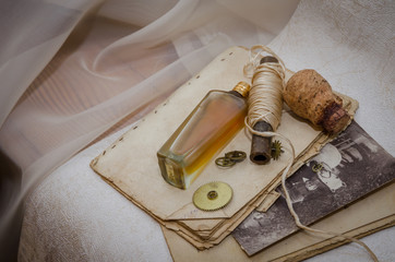 Vintage composition with rustic twine, perfume bottle and old photo