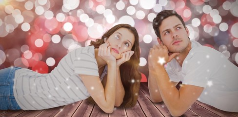 Composite image of couple lying on floor and looking up