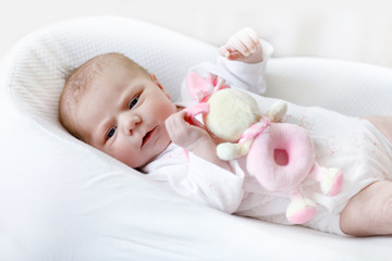 Cute baby girl playing with plush animal toy