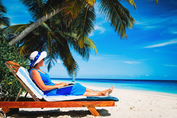 Fototapeta na wymiar remote work- young woman with laptop on beach