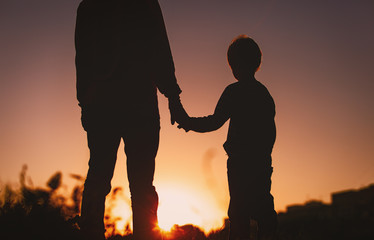 Fototapeta na wymiar silhouette of father and son holding hands at sunset