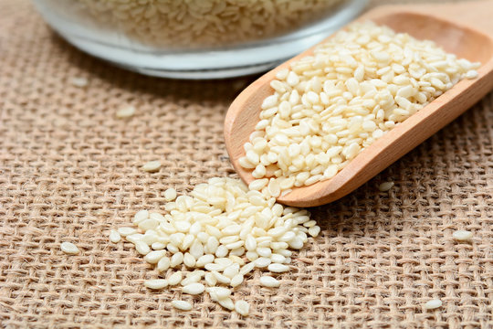 White sesame seeds on wooden spoon