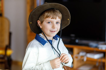 Portrait of little school kid boy wearing cowboy hat