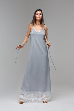 Model in long grey lace nighty standing in studio