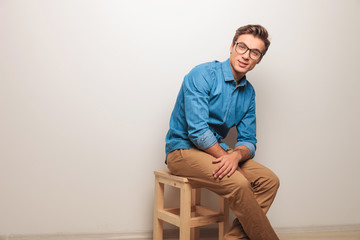 side view of a seated casual man sitting on a chair