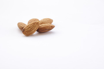 Almonds isolated on a white background, or on a plain wooden table.