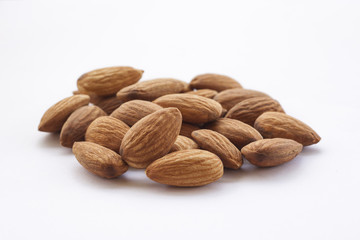 Almonds isolated on a white background, or on a plain wooden table.