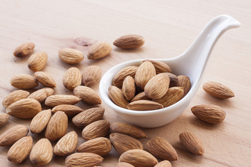 Almonds isolated on a white background, or on a plain wooden table.
