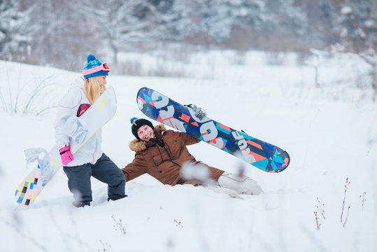 Happy Couple With Snowboards Falling In Snow