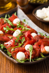 Beef carpaccio served with balls of mozzarella cheese, arugula a