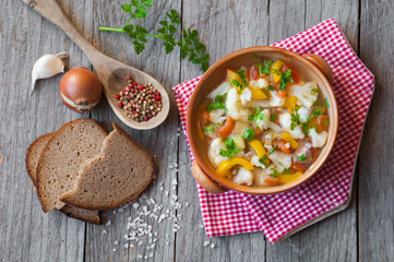 Vegetable soup with bread on wooden table