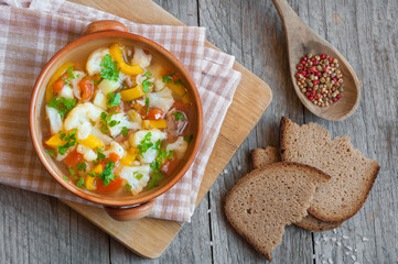 Vegetable soup with bread on wooden table