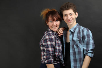 Beautiful cheerful couple posing on a dark background. Family relationships