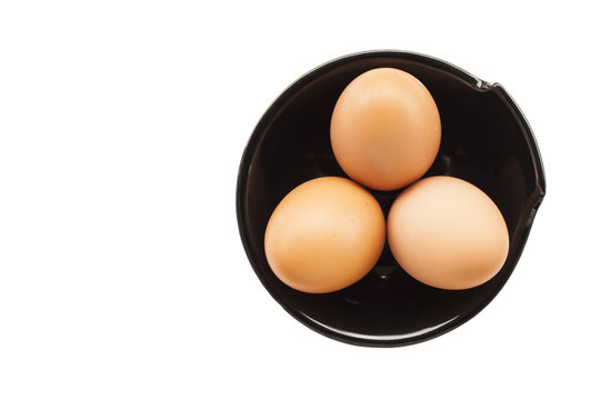 Eggs cooking for breakfast, a protein form yolk and albumen on a white background, or on a plain wooden table.
