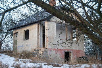 old abandoned ruined house in a garden in winter