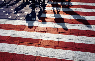 Shadows of group of people walking through the streets with painted Usa flag on the floor. Concept political relations with neighbors. - obrazy, fototapety, plakaty