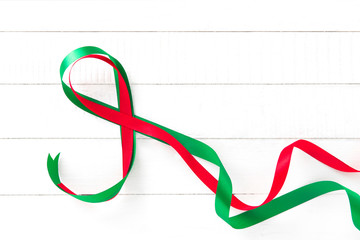 Red and green ribbon on white wood background