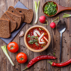 Beet soup in wooden plate with vegetables