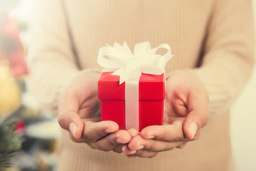 Woman hands giving red gift box